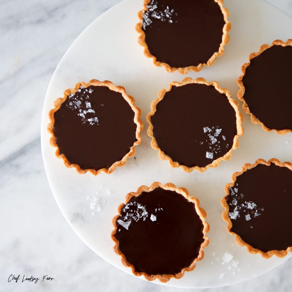 These mini salted chocolate tarts are incredibly easy and perfect for entertaining. The tender almond crust is filled with an irresistibly silky chocolate ganache!